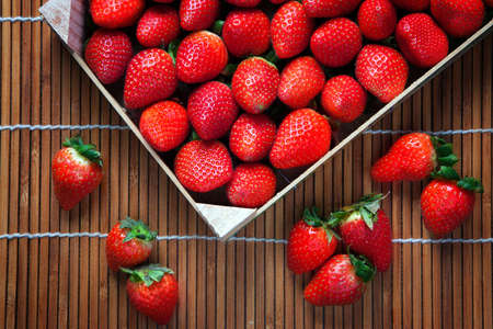 Sstrawberries in the box, top view with wooden background