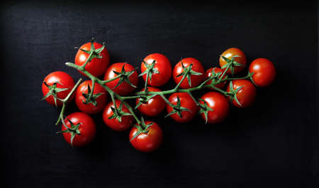 Bunch of tomatoes on dark background.の写真素材