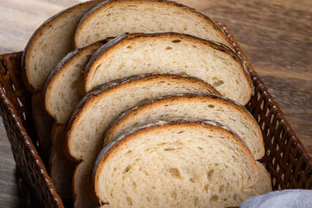 Sliced white bread with wheat flour on a wooden table. Called loaf of bread.