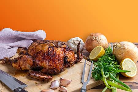 Roast chicken served on the wooden board on the table.の写真素材