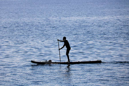 Surfer practicing stand up paddle in Rio de Janeiroの写真素材