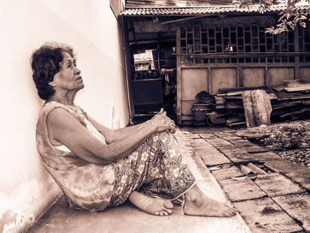 Asian senior woman unhappy while lonely sitting in gardenの写真素材