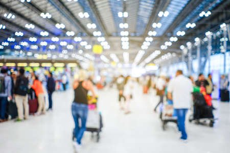 Airport terminal blurred crowd of Travelling people with bokeh light on the Background. Traveling concept.の写真素材