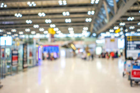 Airport terminal blurred crowd of Travelling people with bokeh light on the Background. Traveling concept.の写真素材