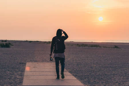 Men walking on sunsetの写真素材