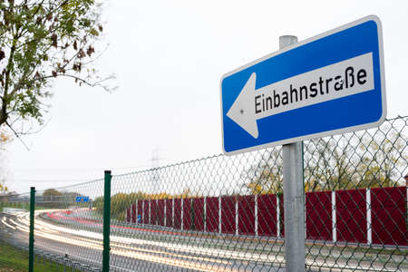 One-way street sign in front of german highway with light trailsの写真素材