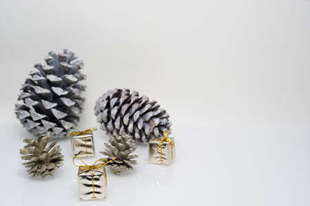 Gold christmas gift boxes with cones on white backgroundの写真素材