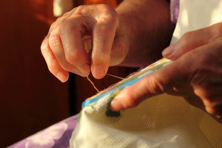 Hands of an old woman busy embroideringの写真素材
