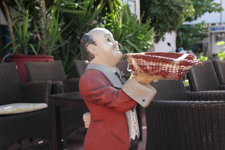 waiter in a red jacket with wicker basketの写真素材