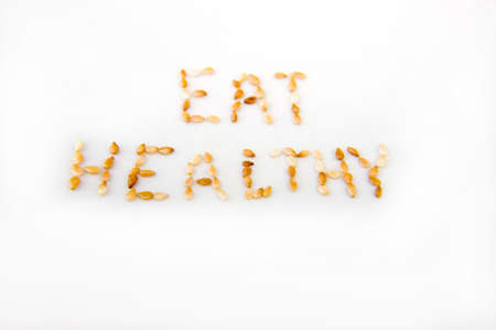 Toasted sesame seeds on a white background spelling out の写真素材