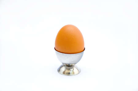 Fresh egg in a cup on a white background with soft shadowsの写真素材