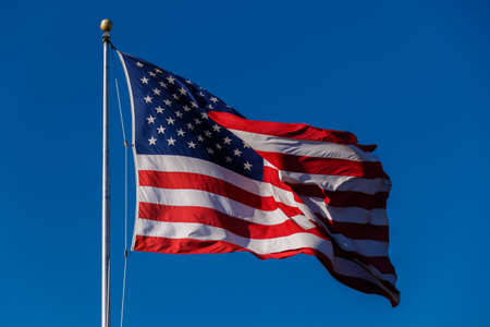 American Flag against blue sky.の写真素材