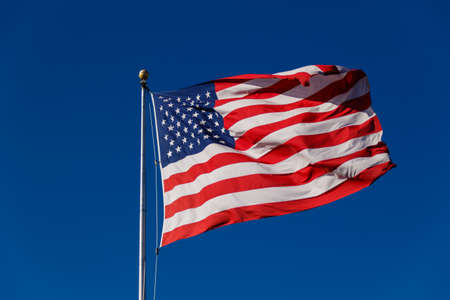 American Flag against blue sky.の写真素材