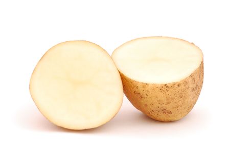 Close-up of raw halved potato on a white background.の写真素材