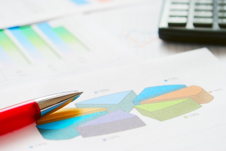 Financial documents with red pen and calculator