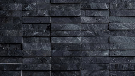 Wall made from black stone tiles as a backgroundの素材