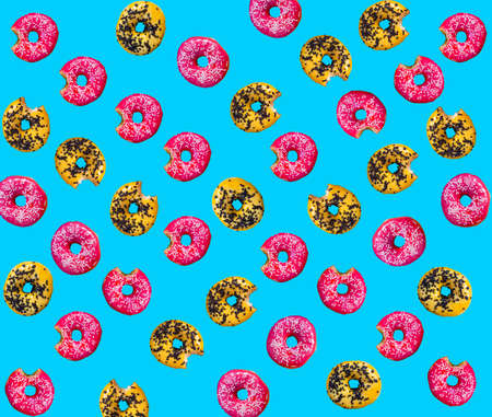 Lots of donuts. Colorful background top view. Yellow, pink color. Circle of bright dessert. Donuts,...