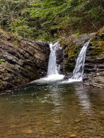 Beautiful mountain waterfall, double waterfall, mountain river. Mountain river in the forest.の写真素材