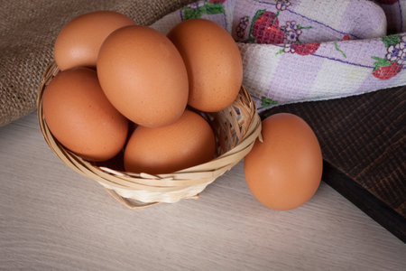 Brown chicken egg close up, fresh eggs in a wicker basket