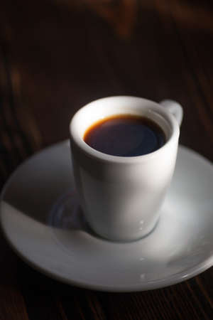 Cup of coffee on a wooden table. Selective focus.