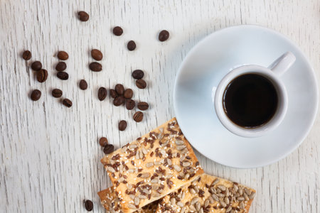 Cup of coffee and cookies with sunflower seeds on wooden backgroundの写真素材