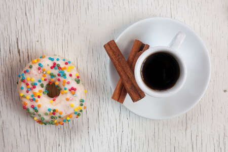 Cup of coffee and donut on wooden background. Top viewの写真素材