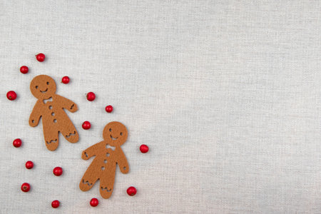 Gingerbread men on wooden background with red berries