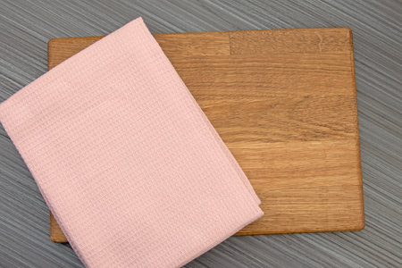 Wooden board, pink tea towel on anthracite board with copy spaceの写真素材