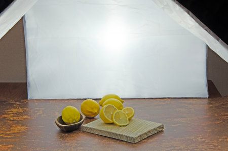 Home photo studio set up of fresh sliced lemons on a wooden board with studio lightingの写真素材
