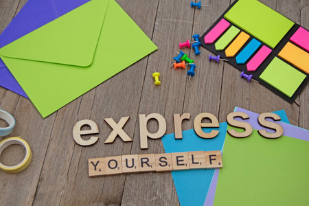 Express yourself letters on wooden board with coloured paper. Coloured tags and envelopes. Coloured push pinsの写真素材