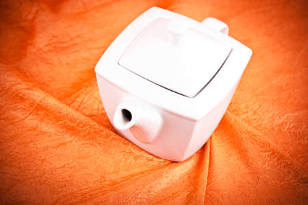 teapot isolated on orange fabric  backgroundの写真素材