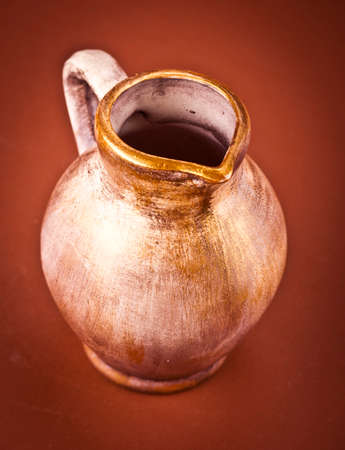 Old ceramic jug on brown  backgroundの写真素材