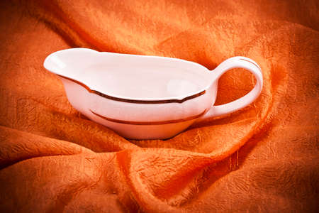 Sauce boat on  orange textile backgroundの写真素材
