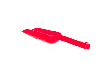Red plastic transfer scoop used in cooking, isolated on white の写真素材