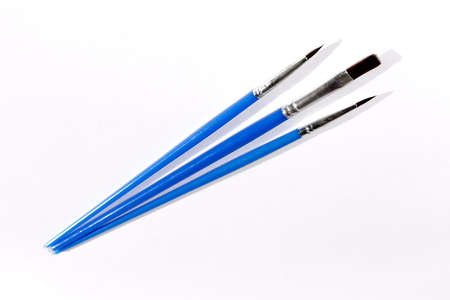 Three artistic brushes are photographed in close-up on a white background. isolate.
