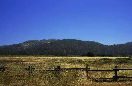 Landscape of a California field with mountains in the background and fence in the foregroundの写真素材