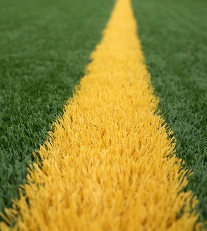Close up of yellow goal line on a green american football fieldの写真素材