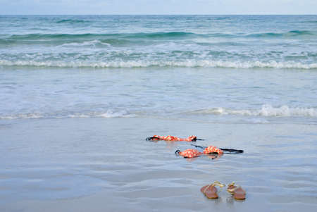 Skinny dipping concept shot showing a bikini on the beachの写真素材