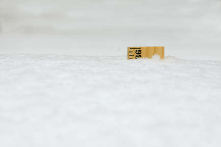 A 36 inch yard stick buried in snow after a blizzard.