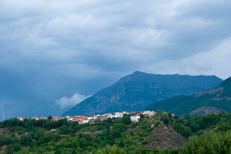 View of a typical Spanish village in the Pyrenees situated on top of a mountain and behind it another highestの写真素材