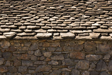 view of a stone wall on which there is a flat roof, overlapping, typical construction of the peoples...