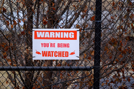 A waning sign for video cameras on a fence.の写真素材