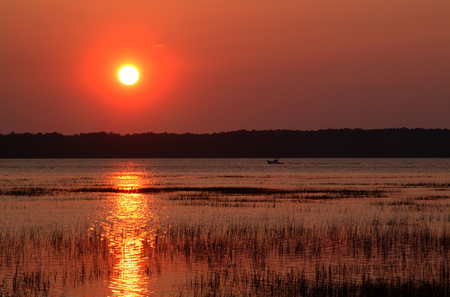 Sunset over the bay with boat in the background.の写真素材