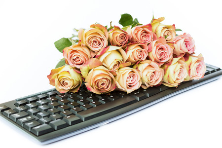 Bouquet of pink roses on keyboard isolated on white backgroundの写真素材