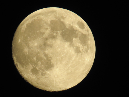 Full round clestial moon in black evening sky. Clear planet with cratersの写真素材