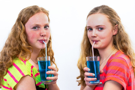 Two caucasian teenage drinking blue sodaの写真素材