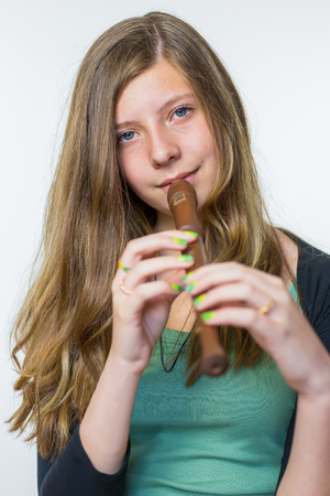Blonde caucasian teenage girl playing the flute isolated on white backgroundの写真素材