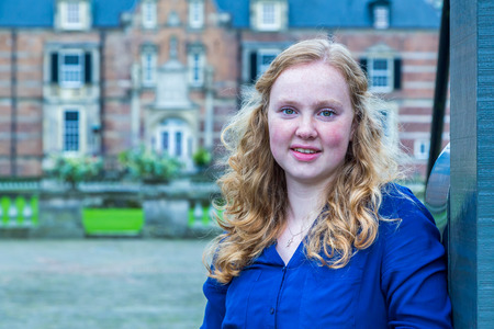 Portrait of european red haired teenage girl with castle on backgroundの写真素材