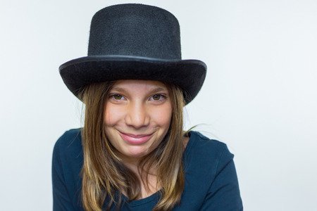 Caucasian teenage girl in black wearing top hat isolated on white backgroundの写真素材