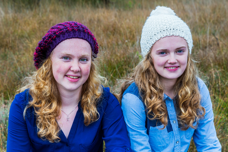 Two european teenage girls wearing hats in natureの写真素材